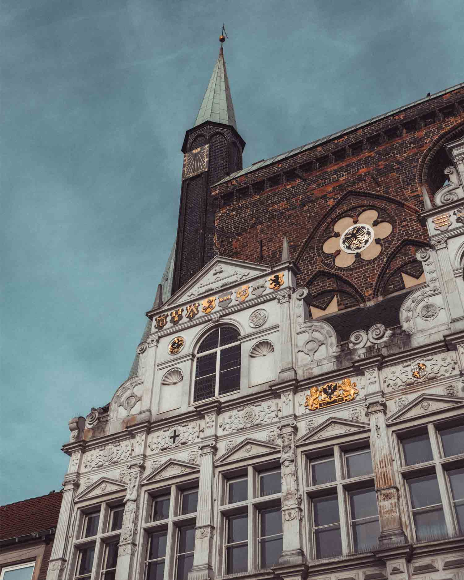 Ein Foto eines Backsteingotischen Kirchturms mit Renaissance-Verzierungen in Lübeck"