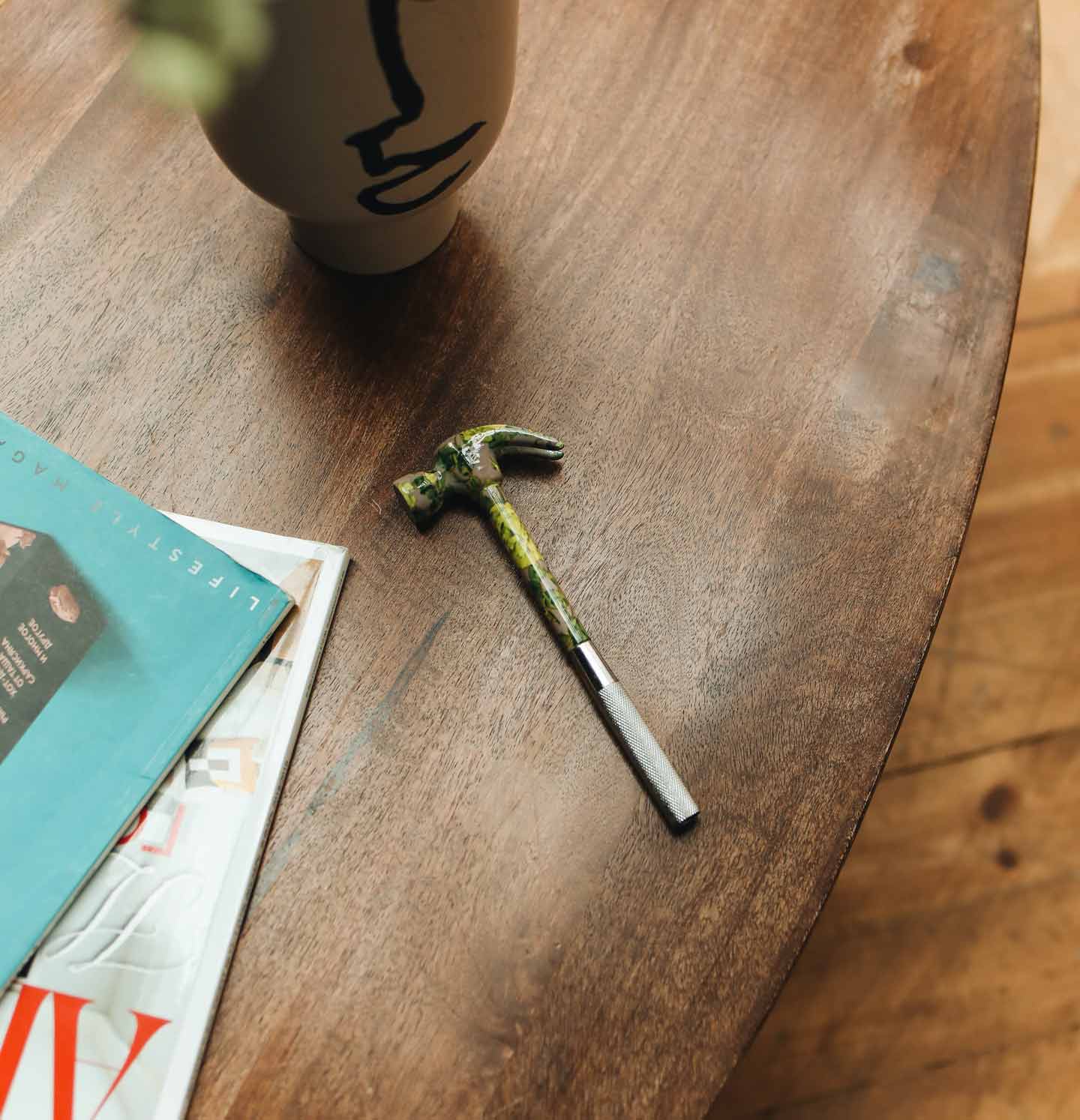 Hammer auf einem hölzernen Tisch, symbolisch für Reparaturen im Bereich der Hausverwaltung.